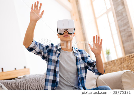Serious adolescent wearing a VR headset 38775381