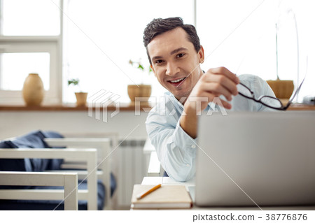 Happy employee holding his glasses 38776876