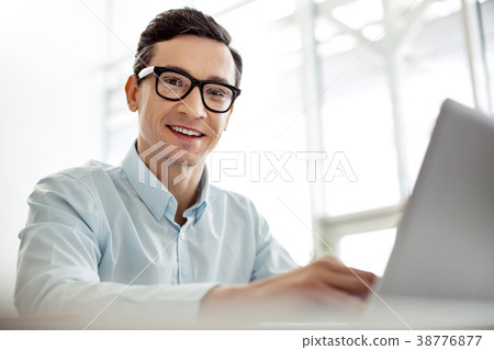 Cheerful worker working on his laptop 38776877