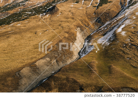 mountain slopes are covered with plants and snow 38777520