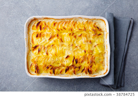 Potato gratin, backed potato slices with sauce. 38784725