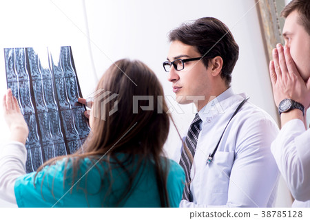 Three doctors discussing scan results of x-ray 38785128