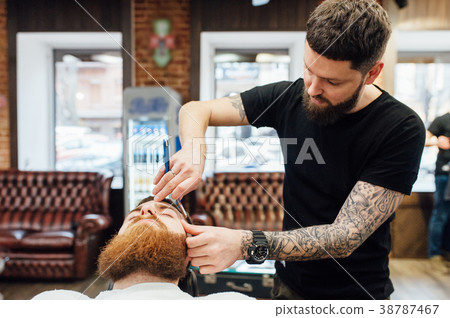 man getting trendy haircut at barber shop. 38787467
