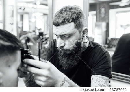man getting trendy haircut at barber shop. 38787621