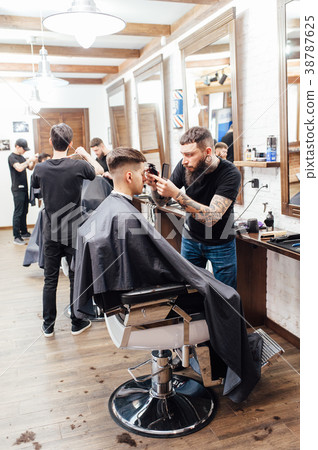 man getting trendy haircut at barber shop. 38787625