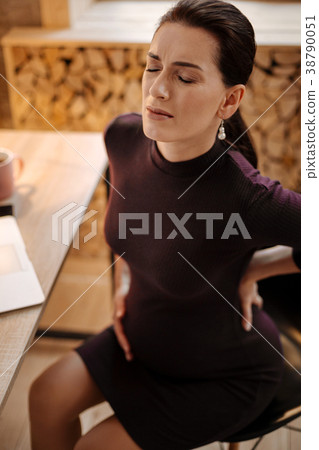 Charming pregnant woman experiencing pain in back Charming pregnant woman experiencing pain in back 38790051