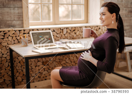 Ambitious pregnant businesswoman relaxing with tea Ambitious pregnant businesswoman relaxing with tea 38790393
