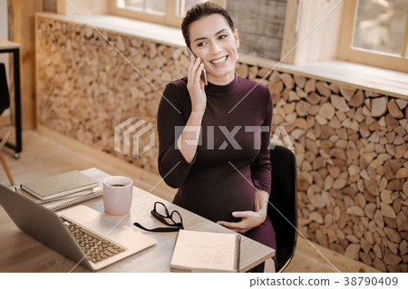 Joyful pregnant businesswoman consulting on phone 38790409