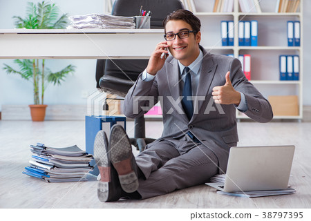 Businessman working and sitting on floor in office Businessman working and sitting on floor in office 38797395
