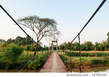 Wooden suspension bridge cross over small river Wooden suspension bridge cross over small river 38798299