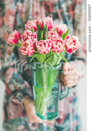 Woman in colorful dress holding bouquet of pink Woman in colorful dress holding bouquet of pink 38800067