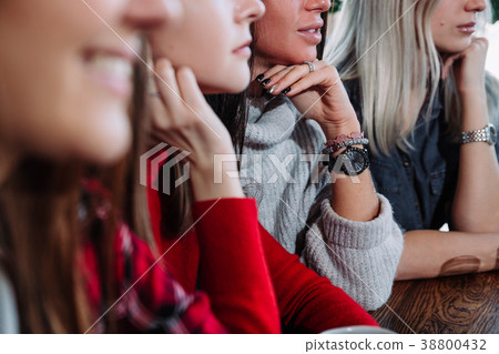 Side view of a Four smiling friends sitting by the 38800432