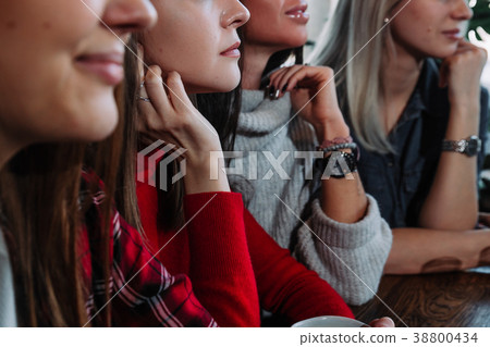 Side view of a Four smiling friends sitting by the 38800434