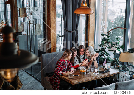 four friends look at the phone and laugh 38800436