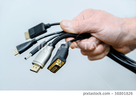 The  various cords and plugs in the hand. 38801826