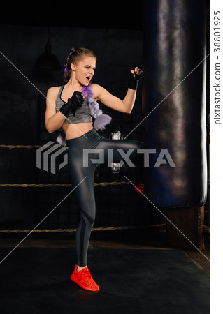 Young woman trains in boxing ring with heavy Young woman trains in boxing ring with heavy 38801925