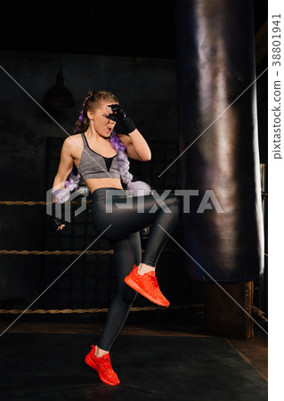 Young woman trains in boxing ring with heavy 38801941