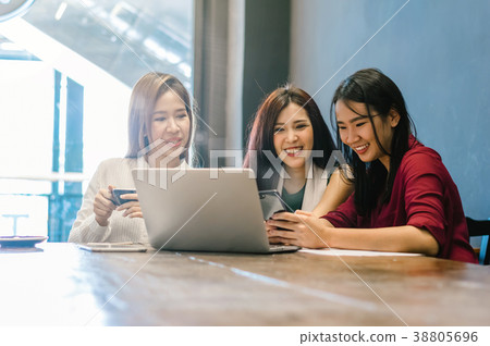 Group Of Asian Businesswomen with casual suit brainstorm Meeting with looking at the laptop and smart mobile phone In the coffee shop, business technology concept Group Of Asian Businesswomen with casual suit brainstorm Meeting with looking at the laptop and smart mobile phone In the coffee shop, business technology concept 38805696