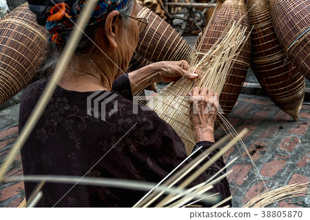Closeup Old Vietnamese female craftsman hands making the traditional bamboo fish trap or weave at the old traditional house in Thu sy trade village, Hung Yen, Vietnam, traditional artist concept Closeup Old Vietnamese female craftsman hands making the traditional bamboo fish trap or weave at the old traditional house in Thu sy trade village, Hung Yen, Vietnam, traditional artist concept 38805870