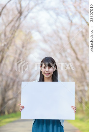 A young lady with a message board in the park Spring 38807010