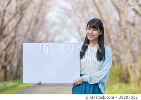 A young lady with a message board in the park Spring 38807018