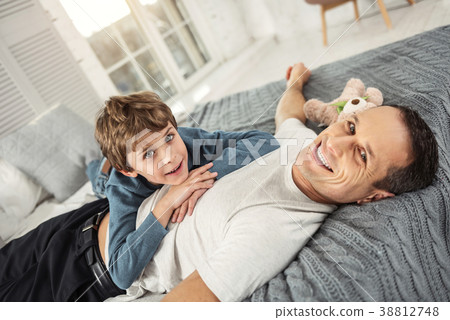 Joyful son and daddy relaxing on bed 38812748