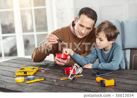 Smiling daddy showing instruments to his son 38813034