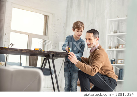 Alert daddy helping his son measure the table Alert daddy helping his son measure the table 38813354