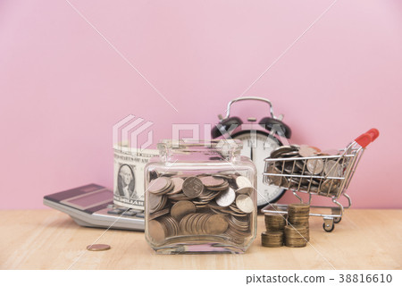 piggy bank and coin in shopping cart on table. piggy bank and coin in shopping cart on table. 38816610