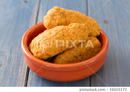 cod fish croquettes on dish on blue background 38820172
