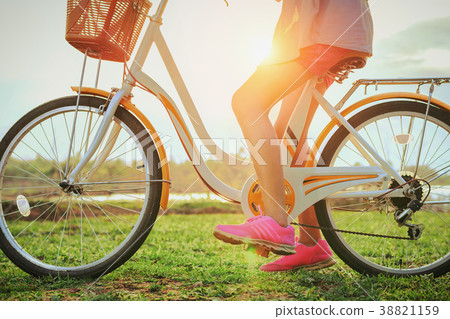 close up leg woman asian on bicycle with sunset 38821159