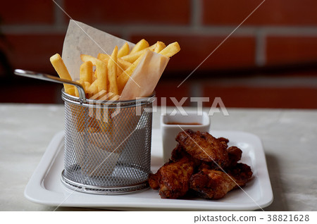 Chicken wings with sauce ketchup and fries in a Chicken wings with sauce ketchup and fries in a 38821628
