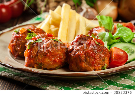 Roasted meatballs in tomato sauce with fries 38823376