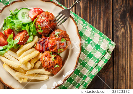 Roasted meatballs in tomato sauce with fries Roasted meatballs in tomato sauce with fries 38823382