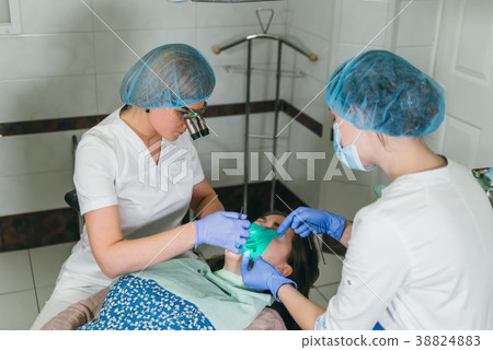 Woman at dentist clinic gets dental treatment to Woman at dentist clinic gets dental treatment to 38824883