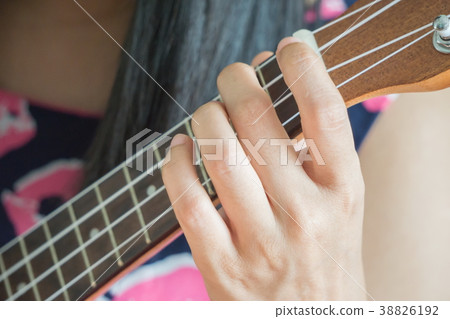 close up hand playing guitar or Ukulele chord. close up hand playing guitar or Ukulele chord. 38826192