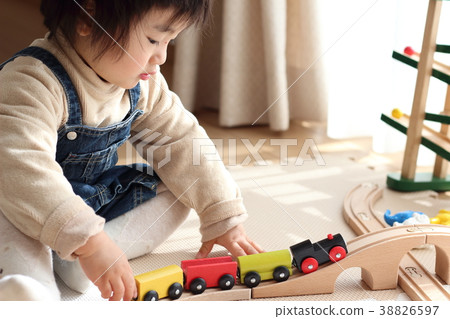 Boy playing with a wooden train Boy playing with a wooden train 38826597