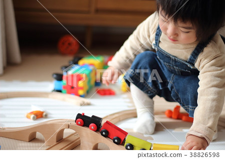 Boy playing with a wooden train 38826598