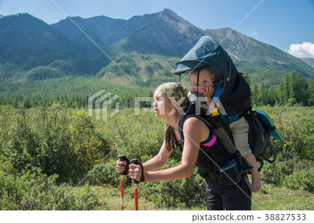 Tired Woman Hiker trekking in mountains with child Tired Woman Hiker trekking in mountains with child 38827533