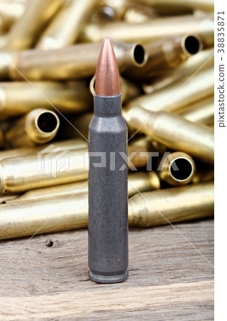 Close-up photo of bullet on the wooden table. 38835871