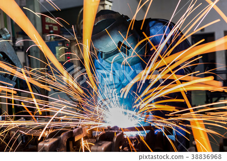 Industrial worker is welding in car factory 38836968