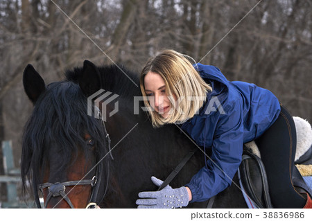 A young girl with white hair is riding a horse. 38836986