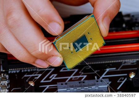 technician is putting the CPU on the socket technician is putting the CPU on the socket 38840597