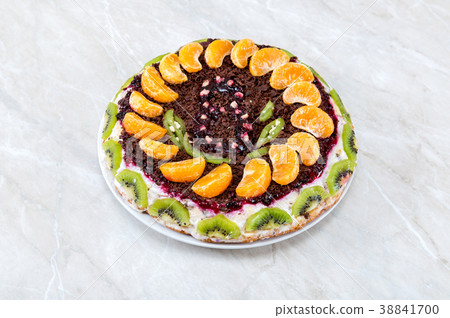 Homemade delicious cake with fruits on a table Homemade delicious cake with fruits on a table 38841700
