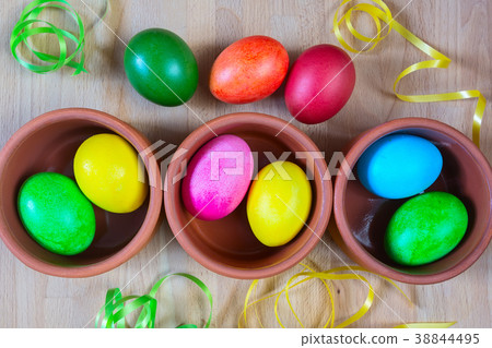 Colored decorated Easter eggs in clay bowls Colored decorated Easter eggs in clay bowls 38844495