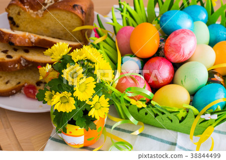 yellow flowers, easter eggs and traditional cake 38844499
