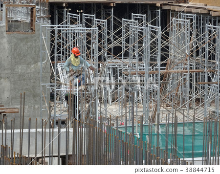 Construction worker installing metal scaffolding Construction worker installing metal scaffolding 38844715