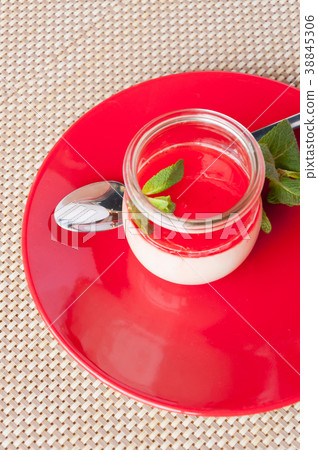 dessert, panacotta with mint on a red plate dessert, panacotta with mint on a red plate 38845306