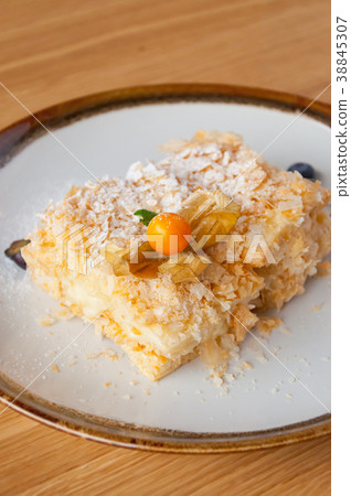 Napoleon cake on a white plate with berries Napoleon cake on a white plate with berries 38845307