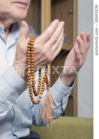 Praying hands of an old man with rosary beads 38845836